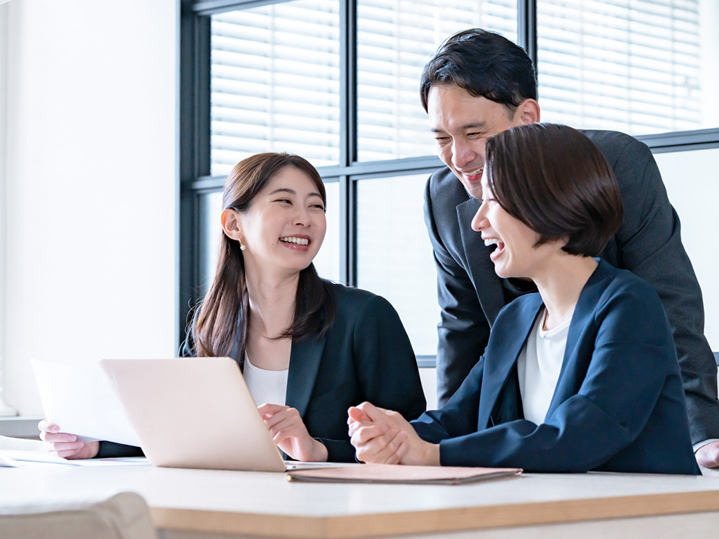 社内で資料を確認しながら話し合う社員の様子